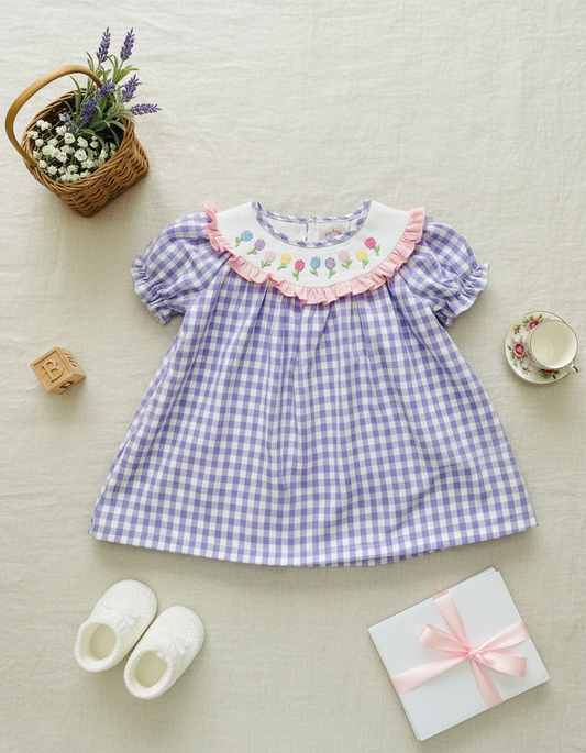 Children's purple checkered dress with floral collar on a light background
