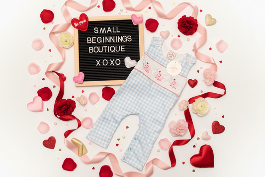 Baby outfit with checkered pattern on a white background with decorative elements and 'Small Beginnings Boutique' sign.